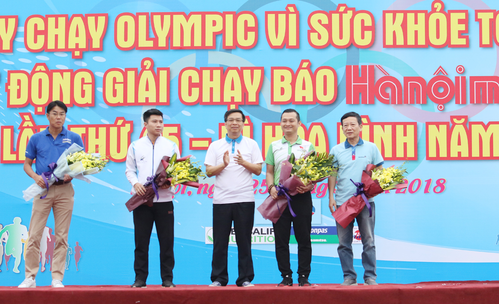 Ông Phạm Tường Huy, Tổng giám đốc Herbalife Việt Nam (áo xanh, thứ hai từ phải sang) nhận hoa cảm ơn từ đại diện Ban tổ chức khi cùng đồng hành, hưởng ứng và truyền tải thông điệp tích cực của Ngày chạy Olympic Run
