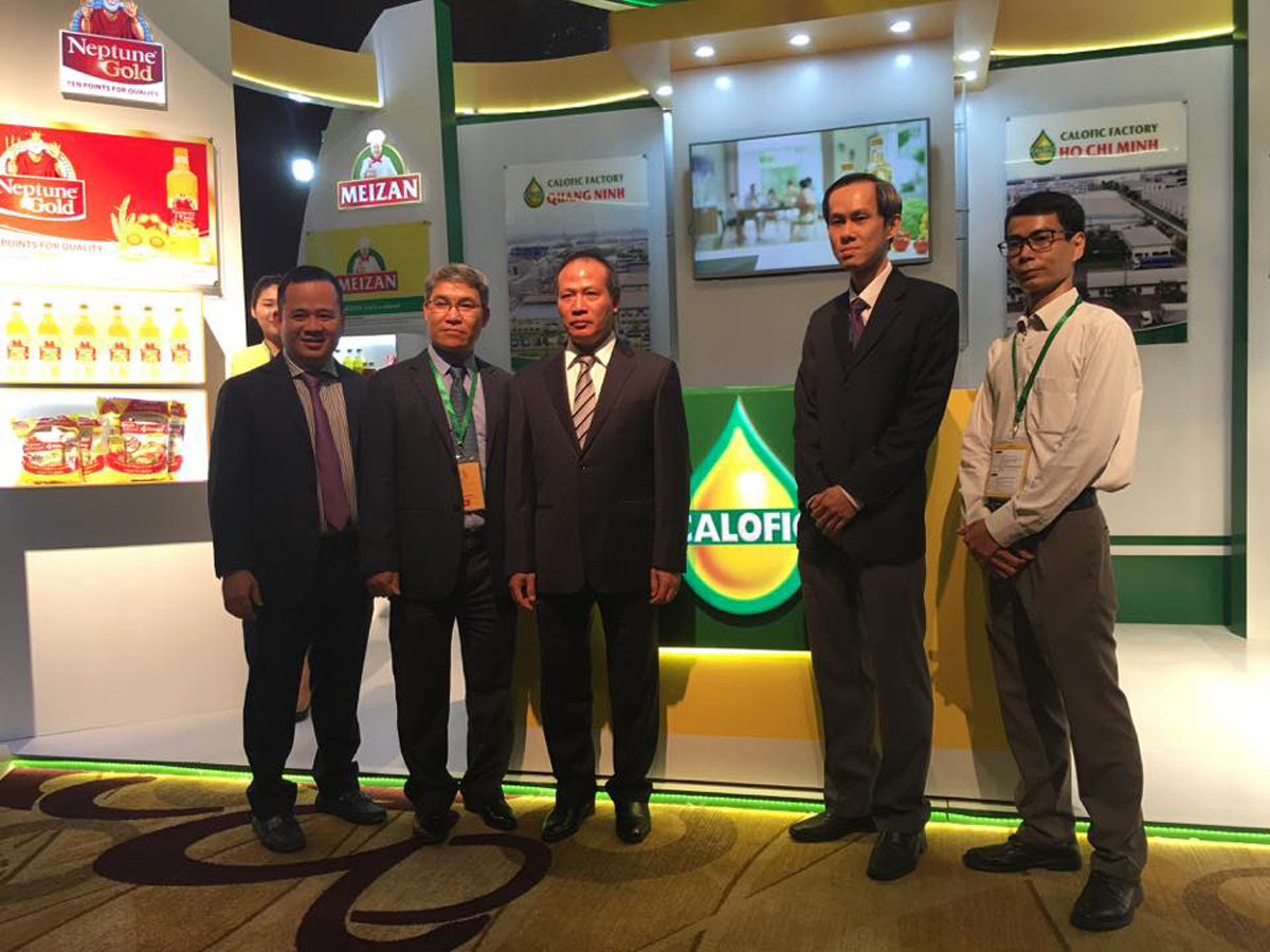Thứ trưởng Bộ Công thương Cao Quốc Hưng và Chủ tịch Hiệp hội Dầu gạo quốc tế Peh Ping Teik chụp ảnh lưu niệm tại gian hàng của Công ty Calofic