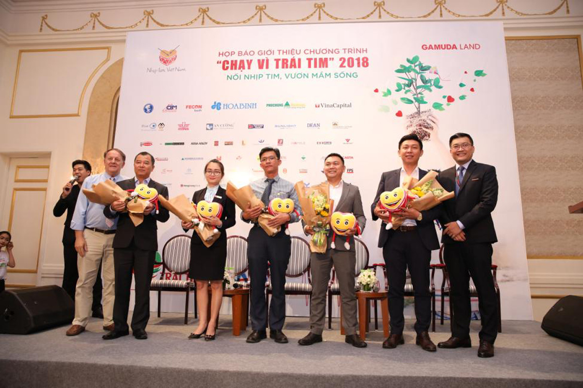 Đại diện FECON South cùng các nhà tài trợ chính nhận hoa trong họp báo khởi động Chạy vì trái tim 2018 