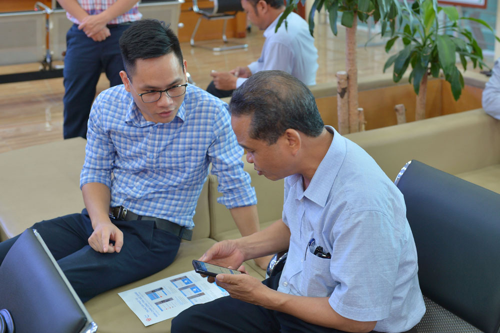 Người dân tra cứu tình trạng giải quyết hồ sơ thủ tục hành chính với sự hướng dẫn của cán bộ Trung tâm Phục vụ hành chính công Bắc Giang