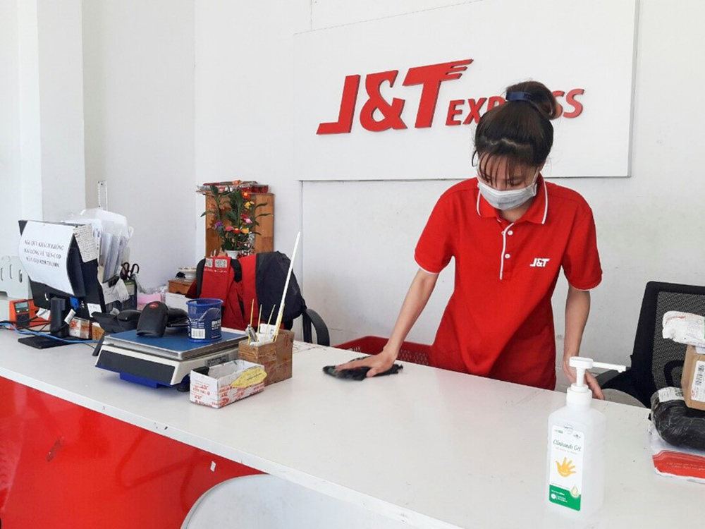 Nhân viên J&T Express tại các bưu cục xịt khử trùng, vệ sinh nơi làm việc trước khi giao dịch với khách