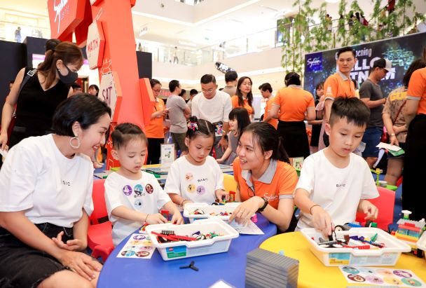 Các con của Ốc Thanh Vân đam mê tham gia trải nghiệm nhận sticker dán đầy áo tại ngày hội Sylvan Learning Việt Nam