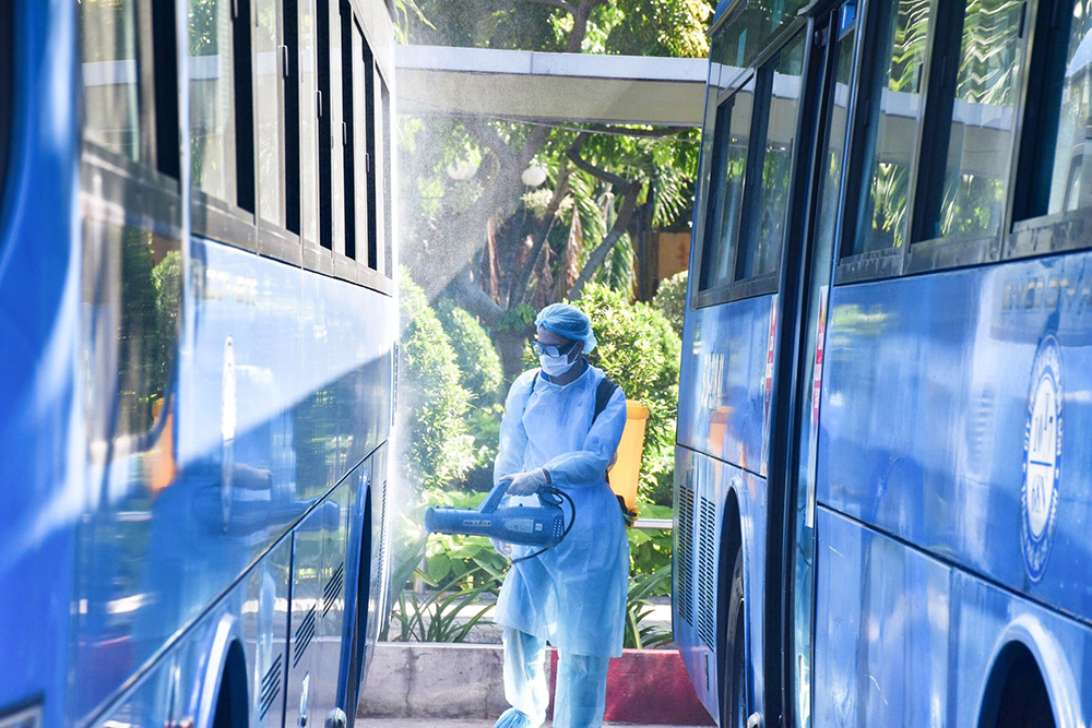 Các đoàn viên phun dung dịch khử khuẩn cho xe buýt và khuôn viên bến xe