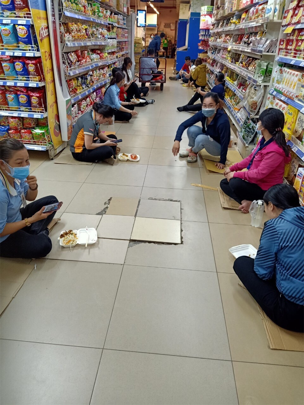Hình ảnh các nhân viên đang cách ly tại một cửa hàng thực phẩm tại quận 1 trong thời gian chờ kết quả xét nghiệm