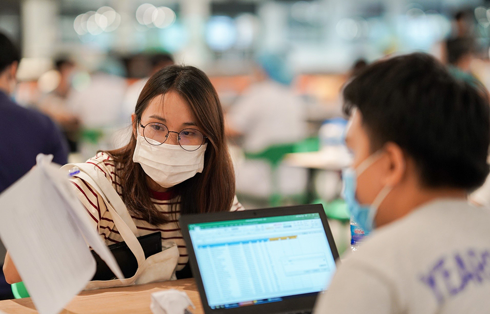 Nhân viên tại công ty thuộc Khu chế xuất Tân Thuận (quận 7) được tư vấn sàng lọc trước khi tiêm vắc xin Covid-19 . Ảnh: Chí Hùng
