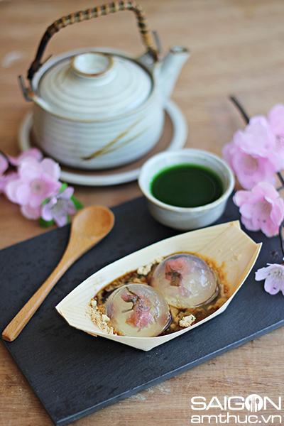 Mochi nước Phiên bản gốc của món bánh này là Shingen mochi – một loại bánh tráng miệng ngon, cực kỳ nổi tiếng với phần phủ trên bánh là bột đậu nành Kinako và si-rô đường nâu. Theo truyền thống, bánh có màu vàng, nhân mềm như thạch bên trong. Ở phiên bản mới mochi nước trong suốt như một giọt nước và tan ngay trong miệng khi thưởng thức. Vì bánh có nguồn gốc xuất xứ từ nước Nhật nên hầu như nguyên liệu đều xuất phát từ Nhật. Trong khi bột đậu nành và si-rô đường nâu dễ tìm mua tại các siêu thị Nhật tại Việt Nam với giá cả phải chăng thì bột agar Nhật lại có giá khá đắt và không sẵn có tại Việt Nam. Agar Nhật được chiết xuất từ rong đỏ, agar Việt Nam được chiết xuất từ rong câu chỉ vàng tại các vùng biển ở Việt Nam. Tận dùng agar Việt Nam để làm ra món bánh có hương vị Nhật bản giải nhiệt cho mùa hè năm nay. 1.	Nguyên liệu : làm bánh này chúng ta cần khuôn bán cầu hoặc khuôn hình cầu nhỏ, nếu không có, chúng ta có thể tận dụng chén nhỏ có hình tròn. -	2gr bột rau câu Hoàng Yến -	400ml nước khoáng hoặc nước tinh khiết -	2g đường -	Bột đậu nành kinako -	Siro đường nâu (có thể mua hoặc tự nấu với liều lượng 100gr đường thốt nốt và 100gr nước, nấu sôi và kẹo lại là được) -	Một ít hoa anh đào muối (tùy chọn) 2.	Cách làm -	Ngâm hoa anh đào vào trong nước sạch để ra bớt vị mặn, sau đó, để ráo và thấm bằng khăn cho khô. -	Bột rau câu và đường trộn chung cho đều và hòa tan với nước. -	Sau đó bắc nồi rau câu lên bếp, đun cho hỗn hợp sôi và tan hoàn toàn. Khi thấy hỗn hợp trong thì tắt bếp, để rau câu nguội bớt (không còn bốc khói) thì bắt đầu đổ vào khuôn hình cầu nhỏ. -	Cho một ít rau câu vào khuôn, sau đó thả hoa anh đào muối vào, tiếp tục rót cho đầy khuôn. -	Cho khuôn vào tủ lạnh qua đêm hoặc 4-6 giờ đồng hồ. -	Khi thưởng thức, lấy bánh nhẹ nhàng ra khỏi khuôn, rưới nước đường nâu và bột đậu nành lên trên. Dùng ngay vì nếu để lâu, bánh sẽ nhanh chảy. 