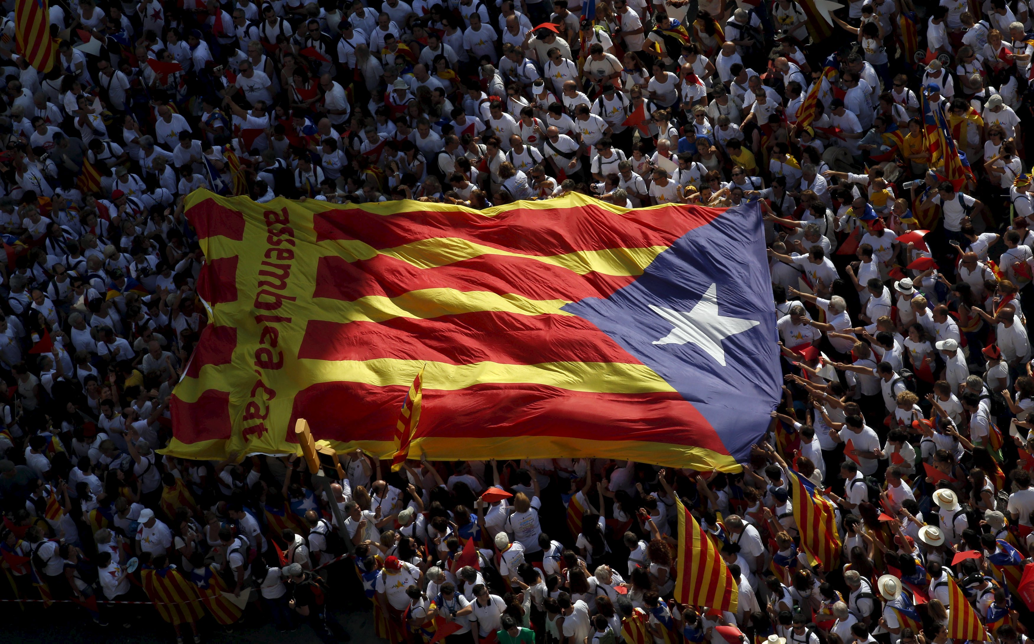 Những người xuống đường tuần hành ở Barcelona đã mang theo lá cờ lớn của riêng xứ Catalonia - Ảnh: Reuters