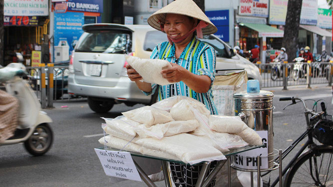 Người lao động nghèo vui mừng với túi gạo miễn phí - Ảnh: Vũ Phượng
