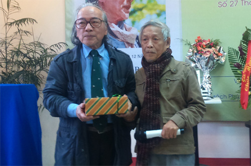  Nhà văn Nguyên Minh, chủ biên của Tập san Quán Văn (phải) tặng sách cho nhà văn, dịch giả Bửu Ý - Ảnh: B.N.L 