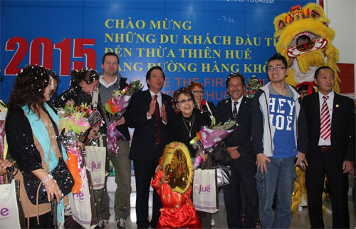 Lãnh đạo ngành du lịch Thừa Thiên- Huế tặng hoa, quà lưu niệm tiếp đón những du khách đầu tiên đến cố đô Huế - Ảnh: B.N.L