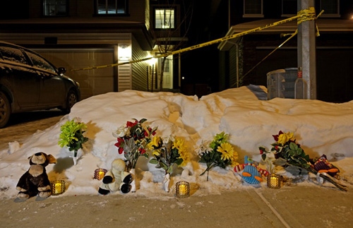  Hoa, nến và thú nhồi bông được đặt trước ngôi nhà có 7 người bị sát hại - Ảnh: Edmonton Journal