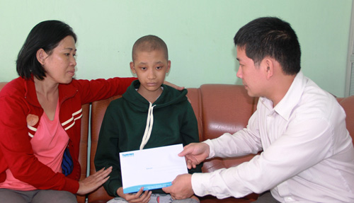 Đại diện Báo Thanh Niên trao tiền cho em Trần Lý Tuệ Nam - Ảnh: Nguyễn Chung