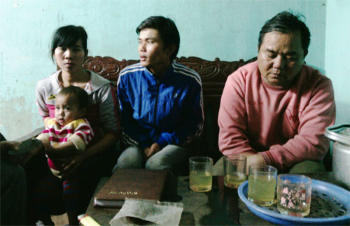 Thanh (người ngồi giữa) cùng bố và vợ con ở Thanh Hóa - Ảnh: Nhật Linh