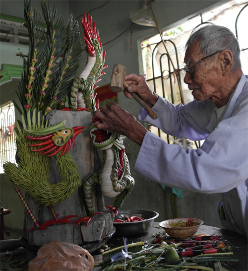 Ông Trần Văn Phúc thực hiện tác phẩm Loan phụng hòa minh bằng hoa quả tươi - Ảnh: Thanh Đức 