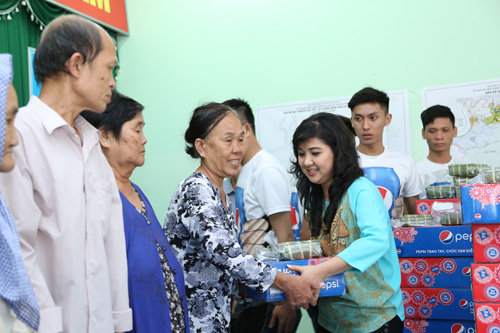 Chị Thanh Hương - đại diện nhãn hàng Pepsi tặng quà tết cho người dân ở huyện Cần Giờ - Ảnh: H.V