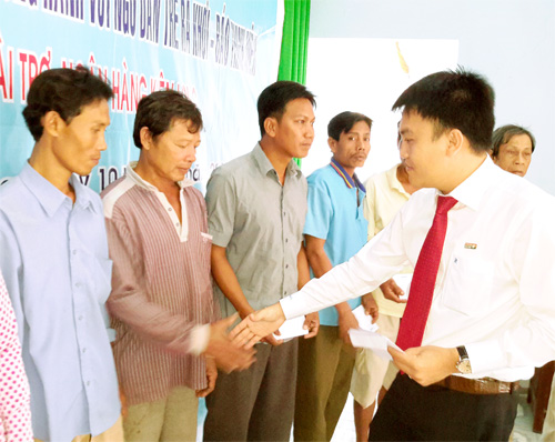 Ông Mạch Quốc Phong, đại diện Ngân hàng TMCP Kiên Long, trao quà tết cho ngư dân - Ảnh: Trần Thanh Phong 