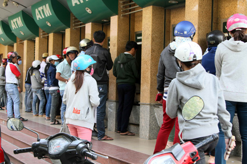 Nhiều người chờ rút tiền từ các máy ATM ở khu chế xuất Tân Thuận - Ảnh: Khả Hòa 
