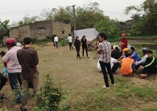 Người dân địa phương tập trung trước ngõ vào nhà của nạn nhân Nguyễn Văn Tình - Ảnh: Tuấn Dũng