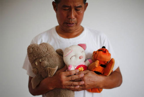 Người cha của đứa con gái nhỏ mất tích trong vụ MH370 bồi hồi nhìn những con thú bông của con - Ảnh:Reuters