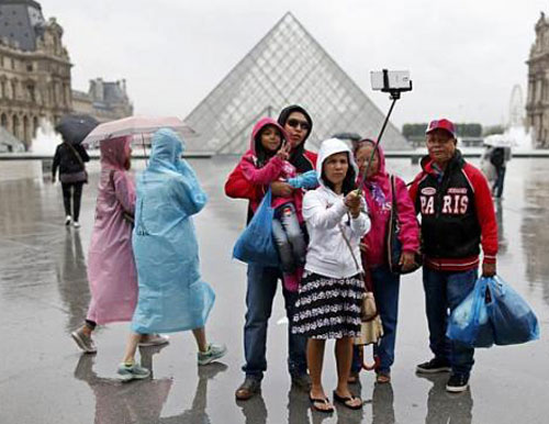 “Gậy tự sướng” đã trở thành dụng cụ không thể thiếu của du khách - Ảnh: AFP