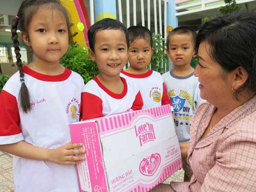 Đại diện Trường mẫu giáo Bé Ngoan 3 trao sữa cho các bé - Ảnh: Phan Thương