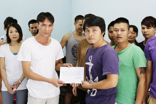Đại diện Báo Thanh Niên (phải) trao tiền cho nhóm lao động - Ảnh: Văn Đạt