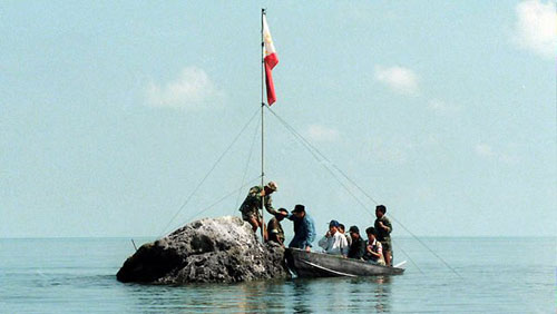 Hải quân Philippines cắm quốc kì trên một mỏm đá ở bãi cạn Scarborough hồi năm 1997 - Ảnh: AFP