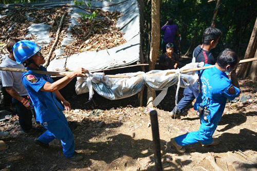 Nhân viên cứu hộ khiêng xác nạn nhân từ ngôi mộ tập thể tại quận Sadao, tỉnh Songkhla (miền nam Thái Lan) - Ảnh: AFP