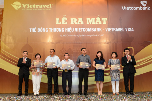 Ông Huỳnh Song Hào - Giám đốc Khối Bán lẻ Vietcombank (ngoài cùng bên phải) và ông Trần Đoàn Thế Duy - Phó Tổng giám đốc Vietravel (ngoài cùng bên trái) trao những tấm thẻ tín dụng quốc tế đồng thương hiệu Vietcombank Vietravel Visa đến các khách hàng đầu tiên
