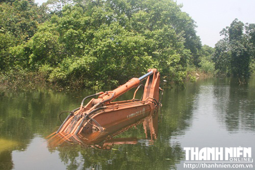 Chiếc máy xúc của một đơn vị thi công tuyến đường xuyên đảo bị chìm trong nước