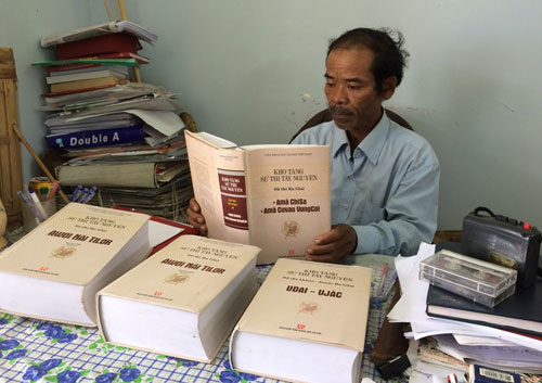 Nghệ nhân Mấu Quốc Tiến với những tác phẩm sử thi Raglai được in thành sách - Ảnh: Nguyễn Chung