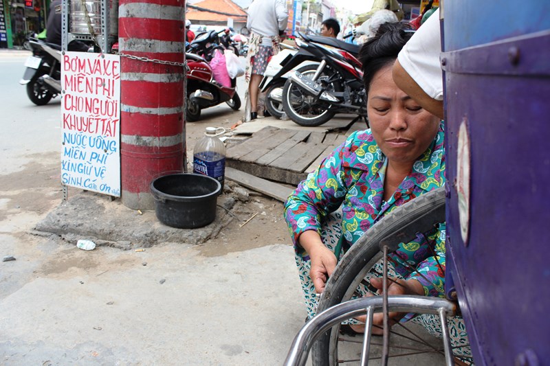 Công việc bom vá xe không phải của mình nhưng chị Trang vẫn sẵn lòng phục vụ miễn phí nếu có người khuyết tật nào cần đến