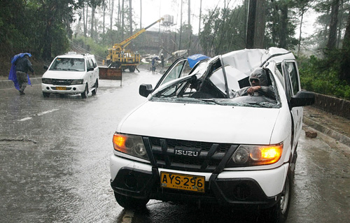 Một chiếc xe hơi bị cột điện đè hư sau khi bão Goni ập vào miền bắc Philippines ngày 21.8 - Ảnh: Reuters