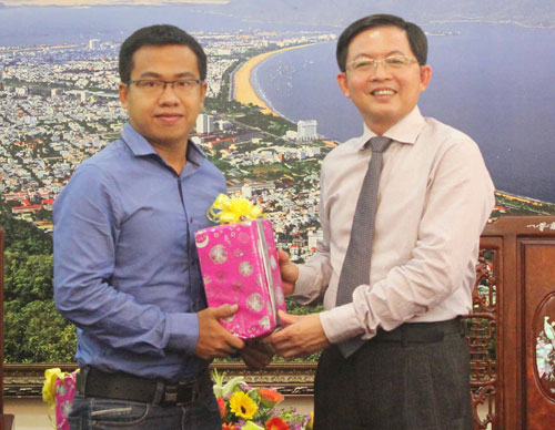 Chủ tịch UBND tỉnh Bình Định Hồ Quốc Dũng (phải) tặng quà cho Nguyễn Sử Phương Phúc - Ảnh: Hoàng Trọng
