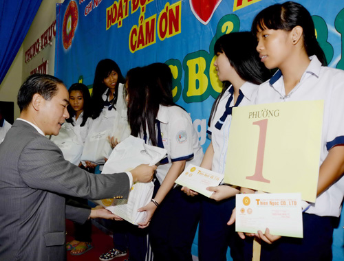 Đại diện nhà tài trợ trao học bổng cho các em học sinh - Ảnh: Diệp Đức Minh