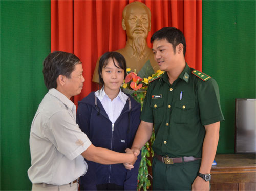 Em Hồ Lê Thảo Nguyên (đứng giữa) cùng gia đình đến cảm ơn trung úy Lương Sơn Trung (bên phải) đã cứu sống em - Ảnh: Vũ Tiến