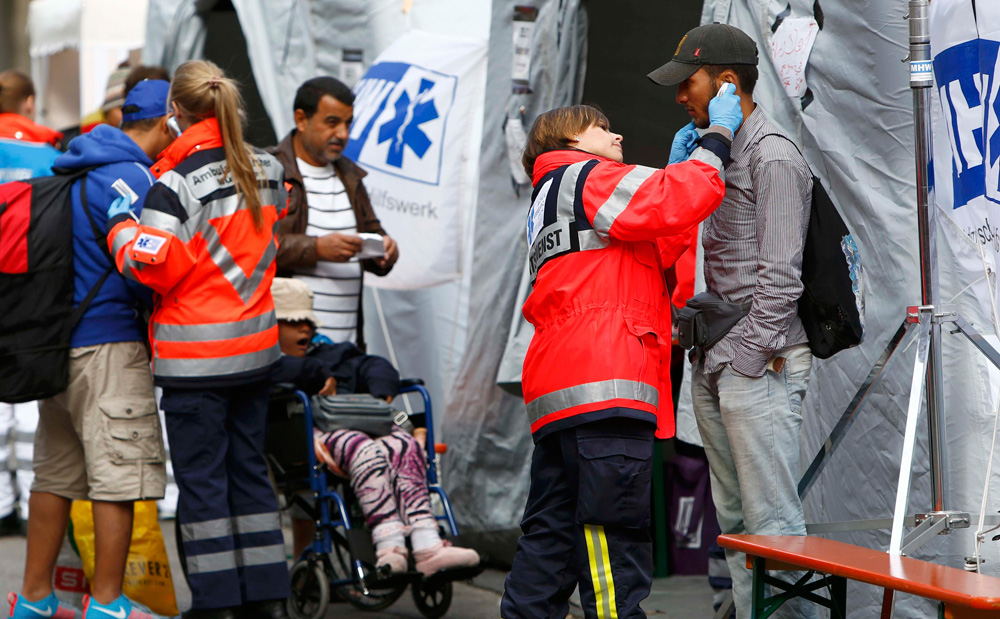 Người nhập cư lậu được kiểm tra sức khỏe tại nhà ga ở Munich, Đức ngày 7.9 - Ảnh: Reuters