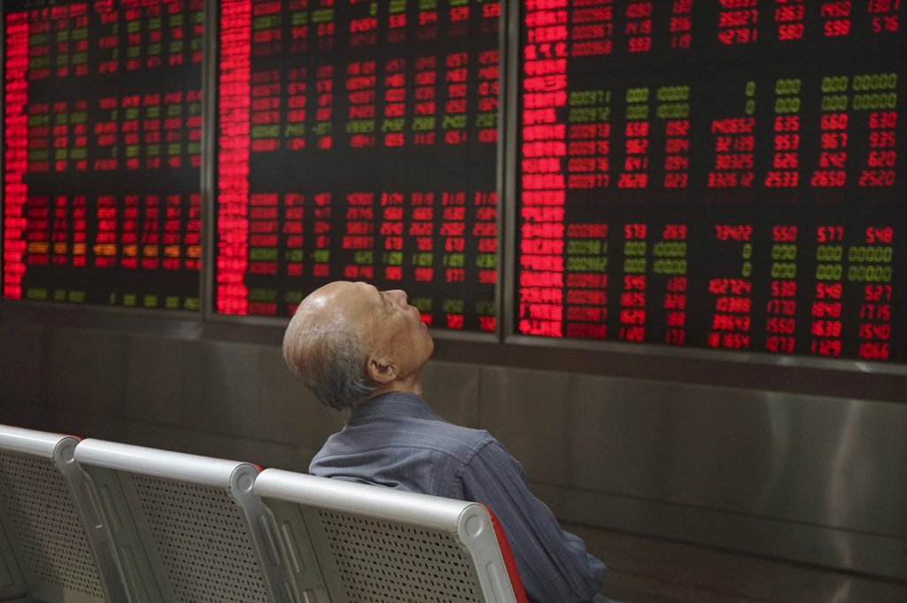 Một người chơi chứng khoán theo dõi thông tin cổ phiếu ở Bắc Kinh ngày 21.9 - Ảnh: Reuters