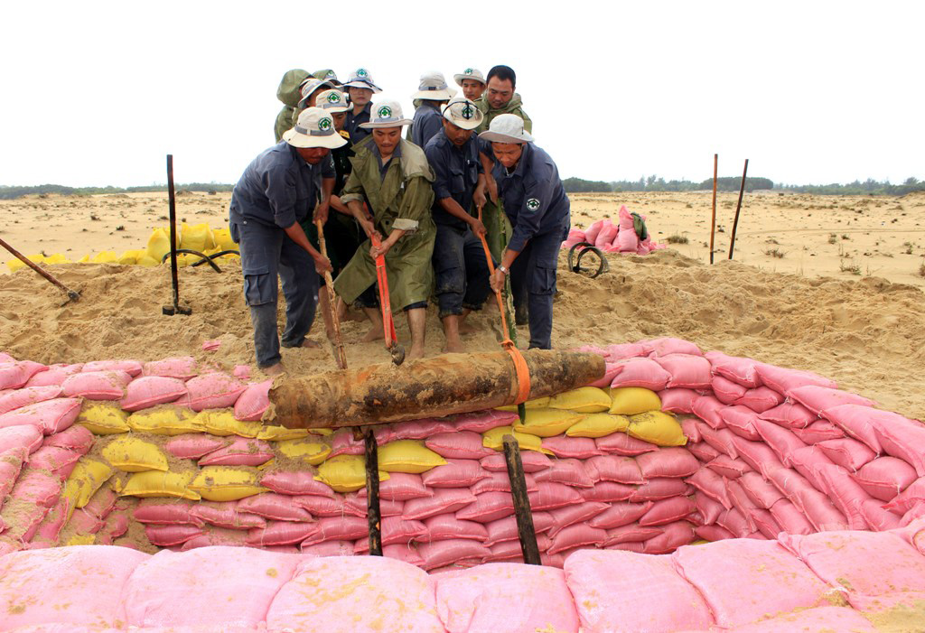  Thành viên đội xử lý bom mìn lưu động đang chuẩn bị đưa quả bom nặng hơn hai tạ xuống hố hủy nổ ở H.Phong Điền (Thừa Thiên Huế)