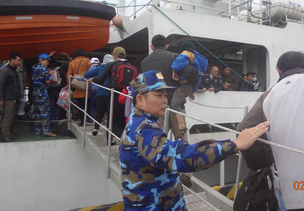 Lực lượng Cảnh sát biển Vùng 2 hướng dẫn, giúp đỡ hành khách lên tàu CSB-8002 - Ảnh: Hiển Cừ