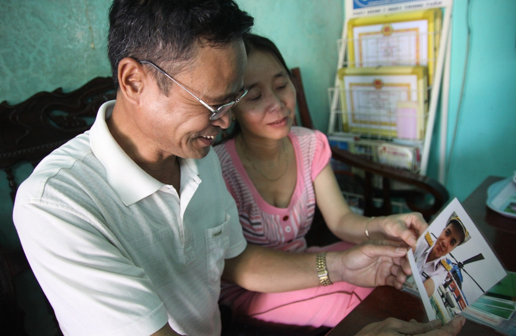 Ở nhà, những lúc nhớ con, ông bà Mạnh, Hương lại lấy những bức ảnh chụp của “cu Bốp” ra xem - Ảnh: Nguyễn Phúc