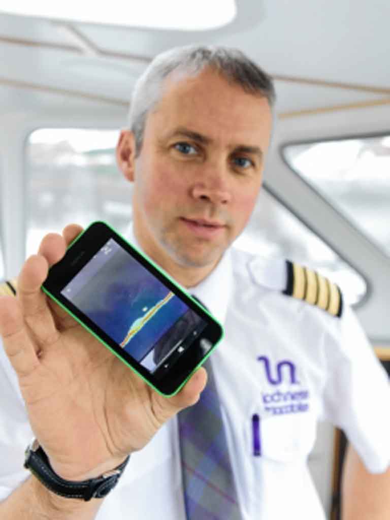 Thuyền trưởng Keith Stewart và ảnh trên điện thoại chụp “vật thể lạ” ở đáy hồ  - Ảnh: Highland-news.co.uk