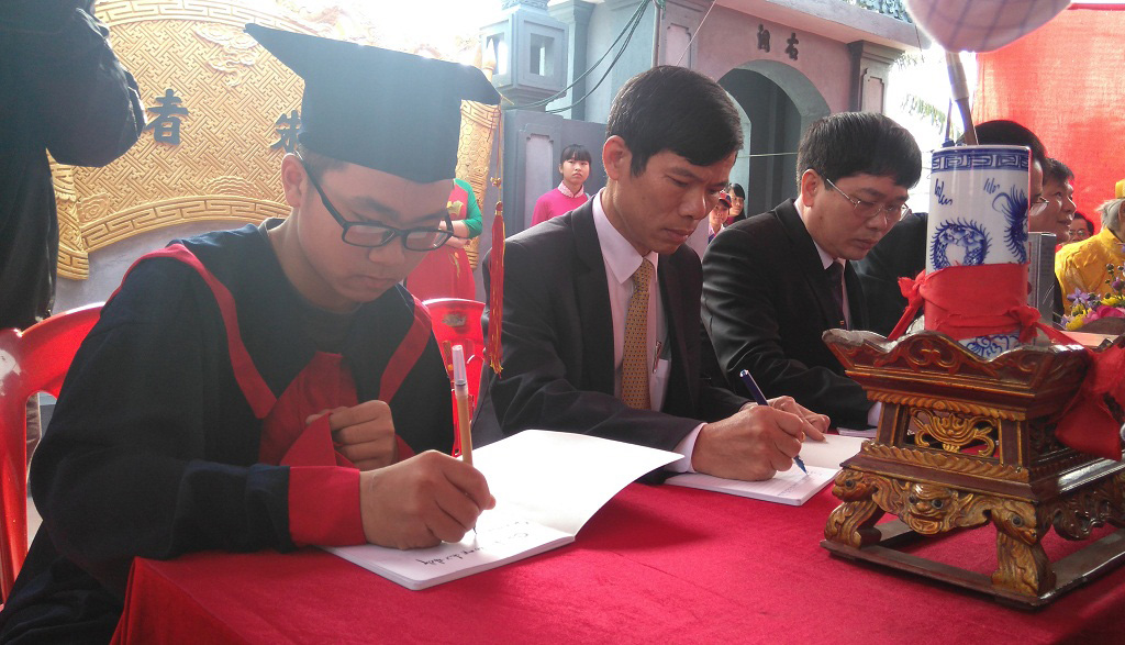 Em Nguyễn Ngọc Thanh (lớp 9A, trường THCS Nam Sơn, huyện An Dương) đạt học sinh giỏi quốc gia năm học 2014-2015 khai bút cùng một số lãnh đạo ban, ngành địa phương - Ảnh: V.N.K