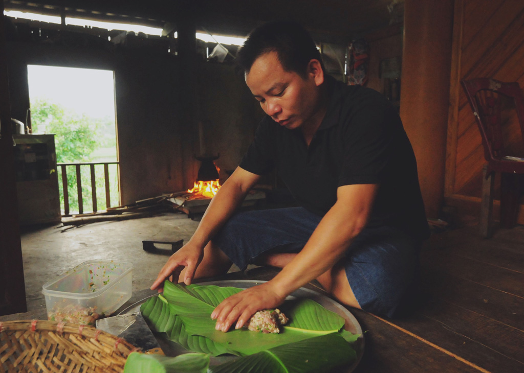 Anh Nguyễn cẩn thận gói thịt vào trong những lớp lá dong. Theo anh Nguyễn, thịt lợn phải được gói kín bên trong, từ 3 đến 5 lớp lá
