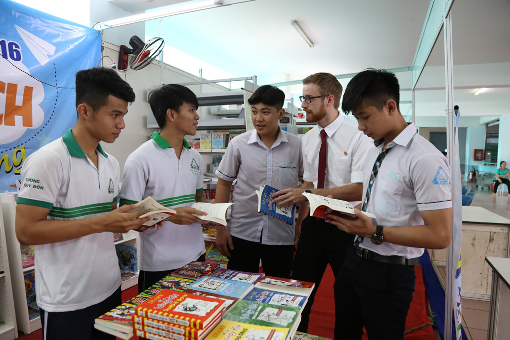 Giáo viên nước ngoài cùng các học sinh Hệ thống Giáo dục TTC cùng trao đổi các loại sách yêu thích tại một gian hàng sách của TTC Edu.