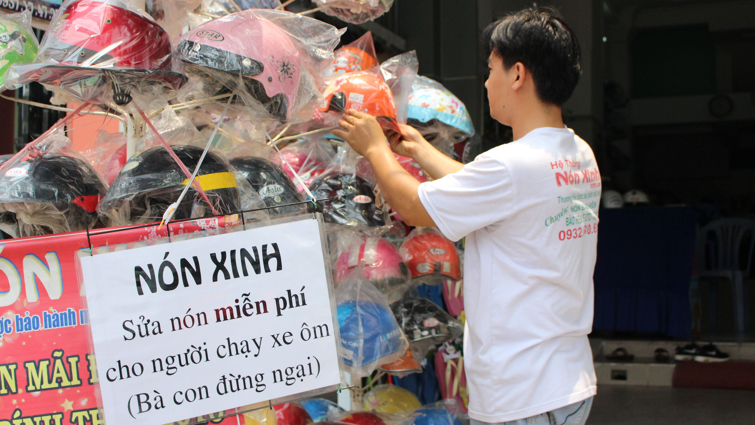 Tất cả các cửa hàng của chị Hồng Nương đều treo bảng sửa nón miễn phí - Ảnh: Vũ Phượng