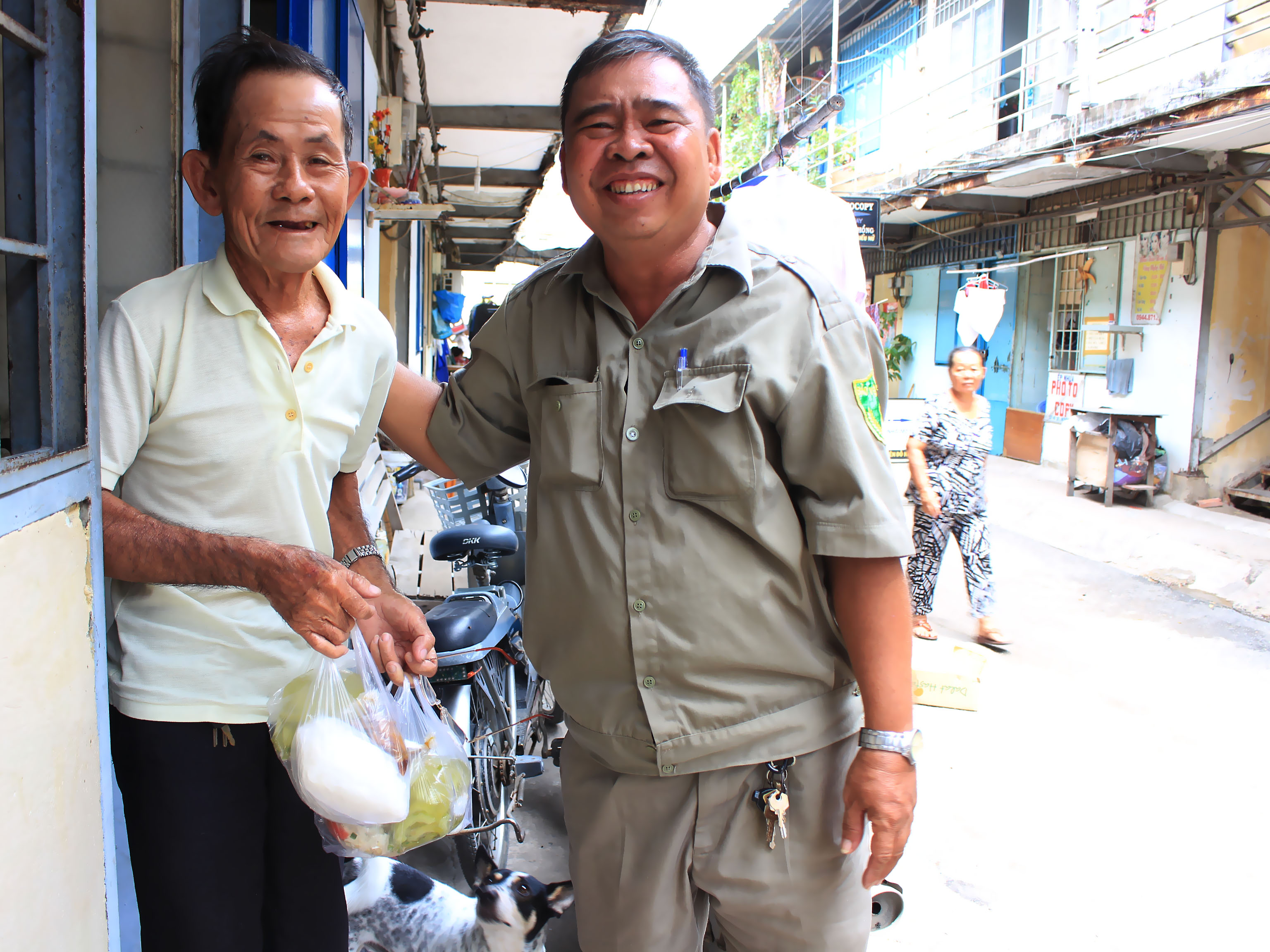 Ông Võ Văn Giàu (53 tuổi, bảo vệ dân phố) mang cơm đến tận nhà cho ông Trần Văn Tuồng (83 tuổi) đang chăm vợ bị liệt và nhiều người già có hoàn cảnh khó khăn nhưng không tới nhận cơm được