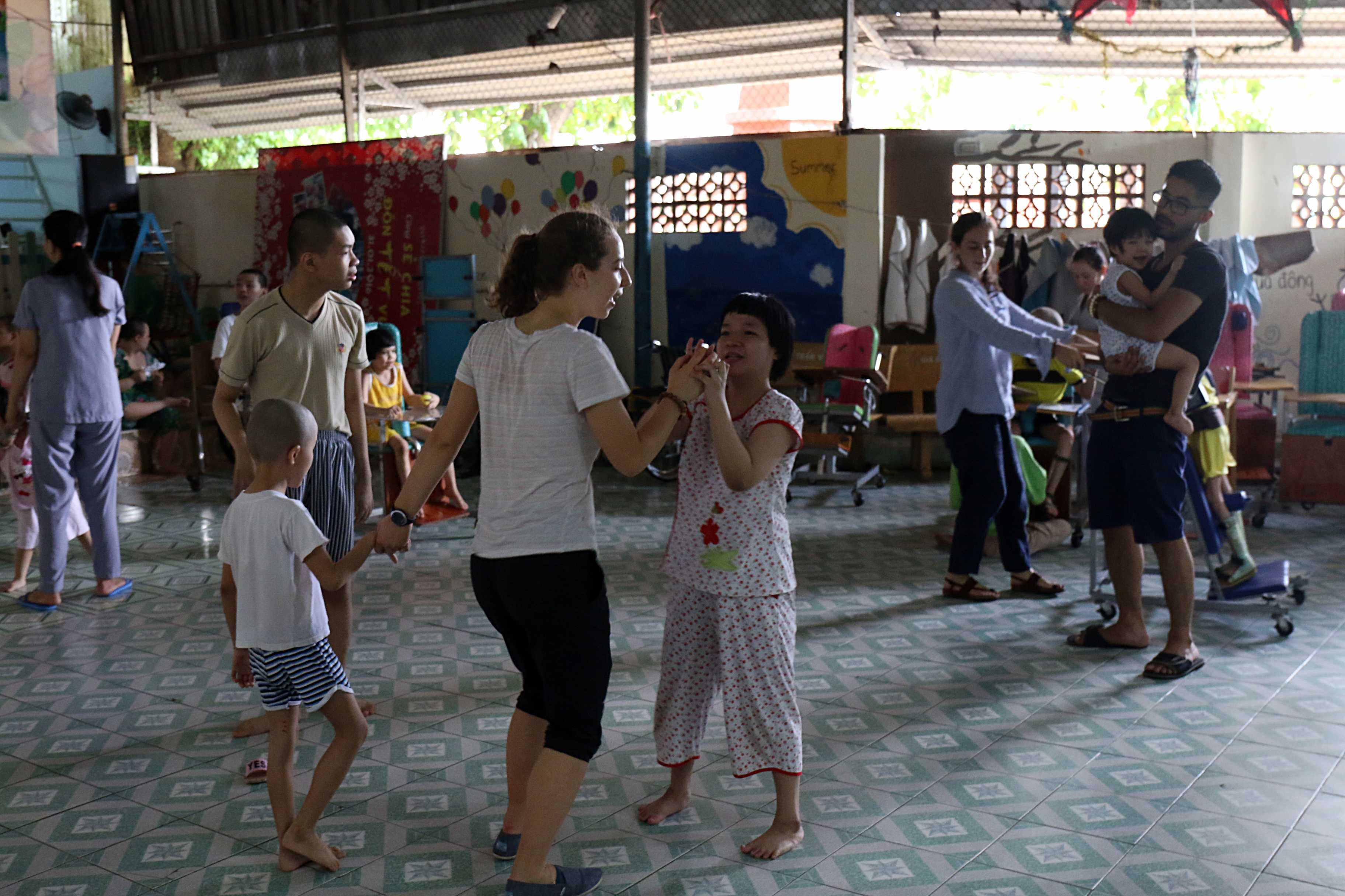Nhóm tình nguyện viên người nước ngoài vui chơi với các em nhỏ bị khuyết tật