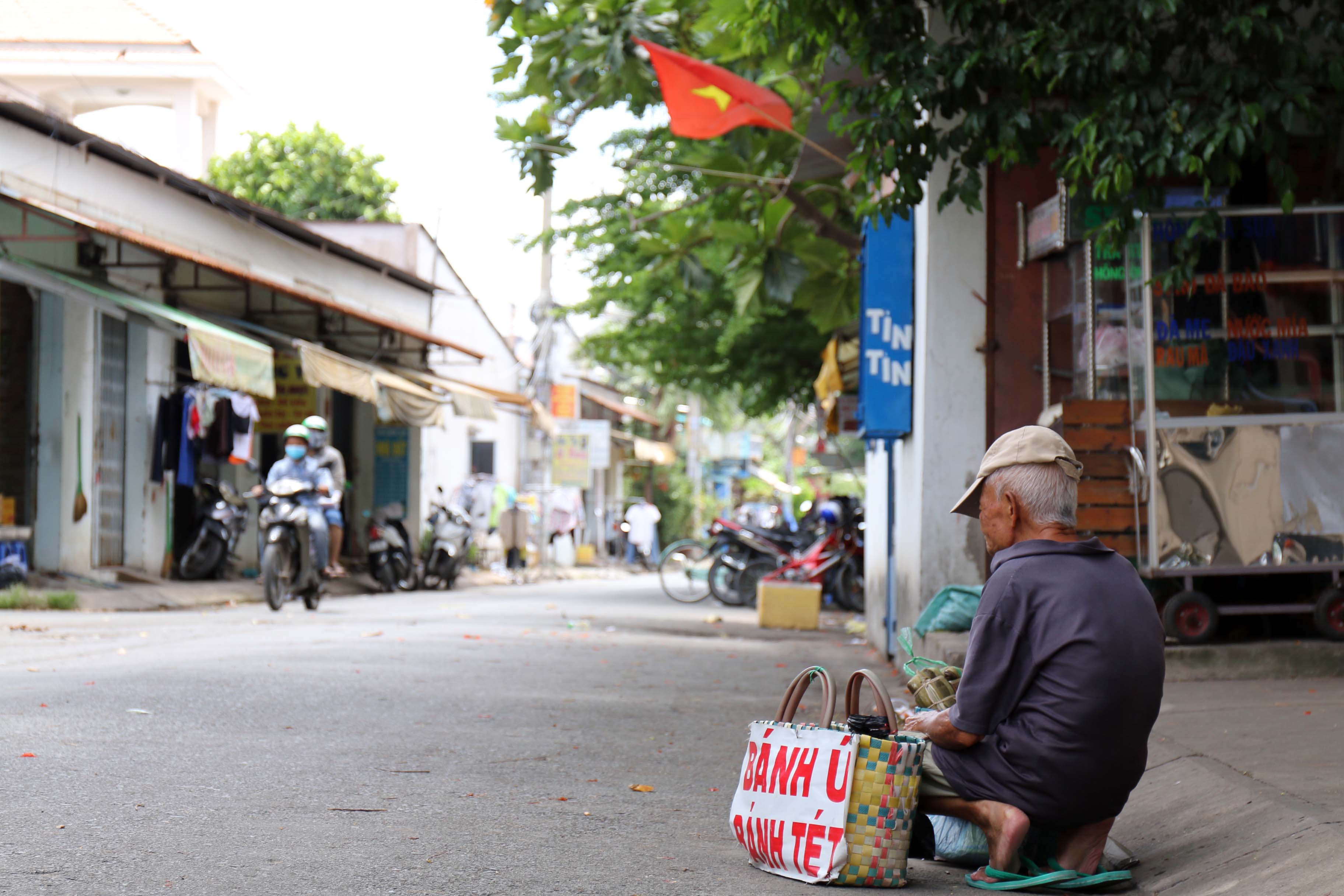 Dáng người nhỏ bé, dù nắng hay mưa cụ Chũm vẫn đều đặn xách giỏ bánh đi bán, đi mệt cụ lại ngồi nghỉ, rồi lại đi...