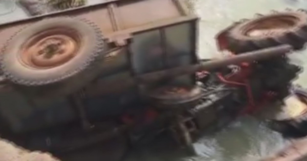 Lái máy cày qua cầu cũ rồi bị rơi xuống sông, một người bất tỉnh